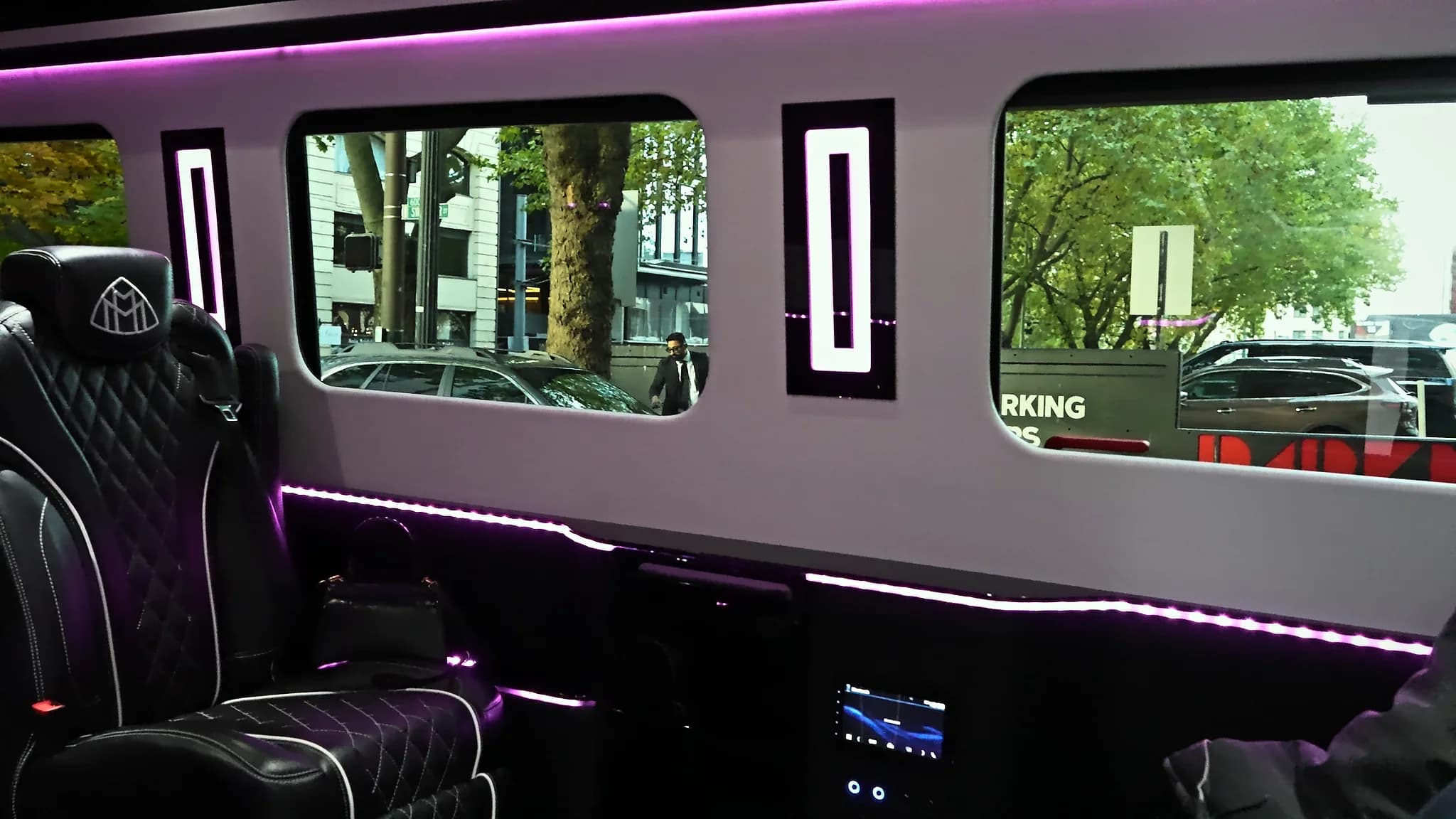 Sprinter Jet Limousine lounge cabin: facing leather seats, lit window panels and violet accent lighting
