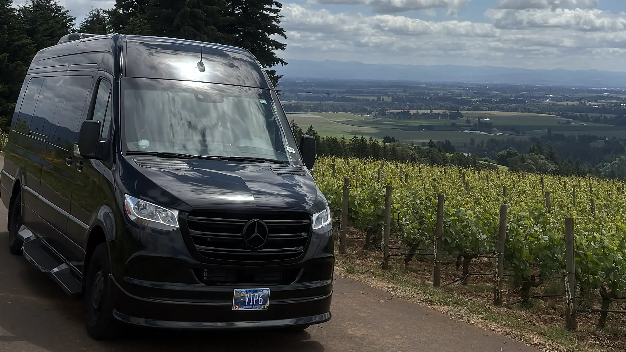 Mercedes-Benz Sprinter on a hillside vineyard road — wine tour transportation in Oregon wine country